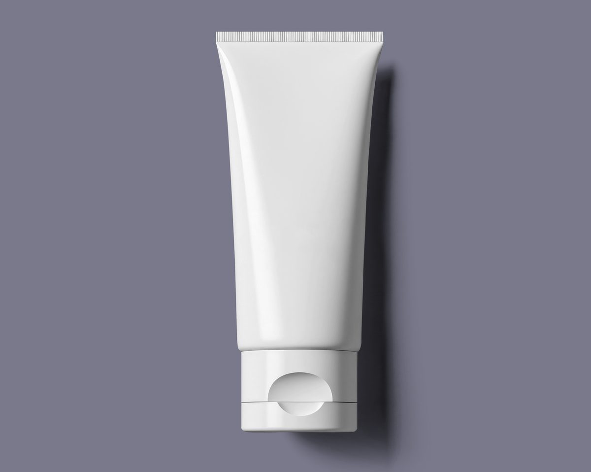 White cosmetic bottle on neutral coloured background
