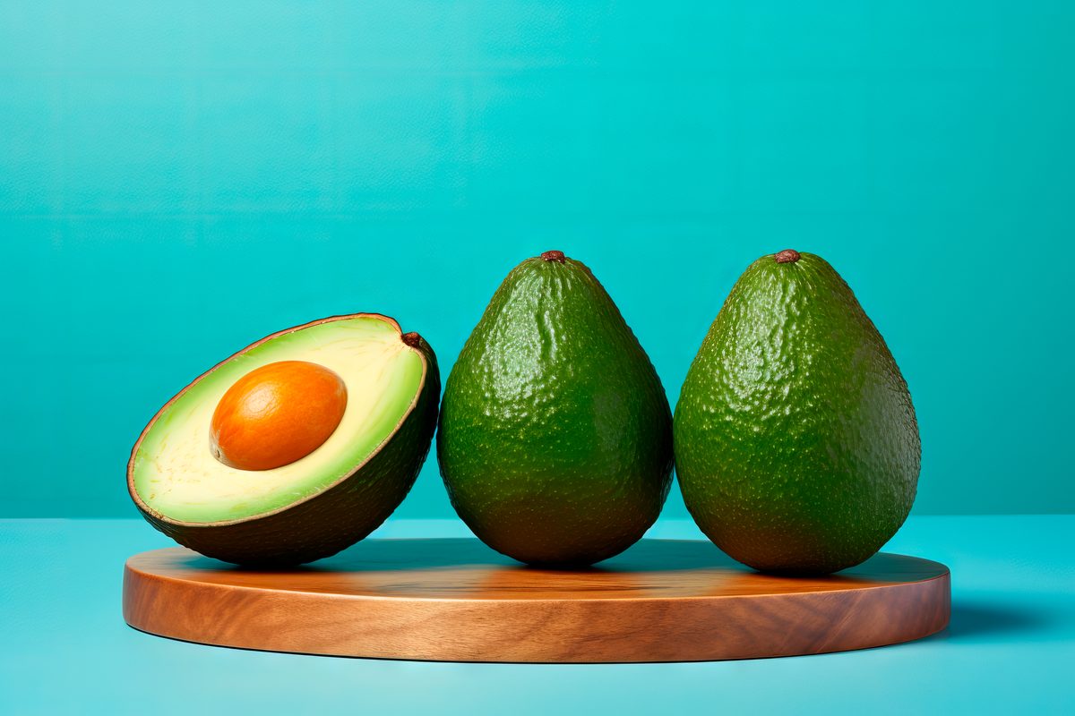Three delicious fresh avocados standing on a blue background